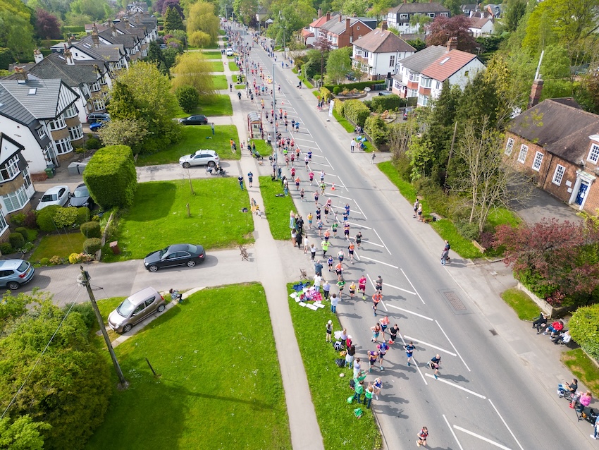 Drone view of runners competing in the Rob Burrow Leeds Marathon race and Half-Marathon running on Otley Road, Adel, at the 6 mile point.